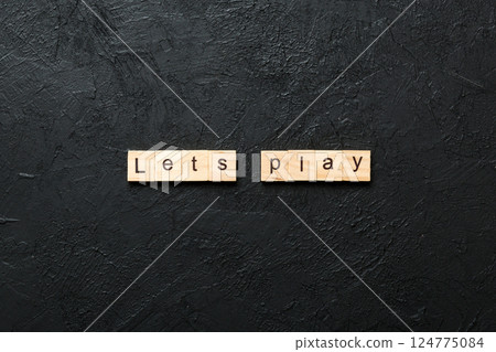 lets play word written on wood block. lets play text on cement table for your desing, concept lets play word written on wood block. lets play text on cement table for your desing, concept 124775084