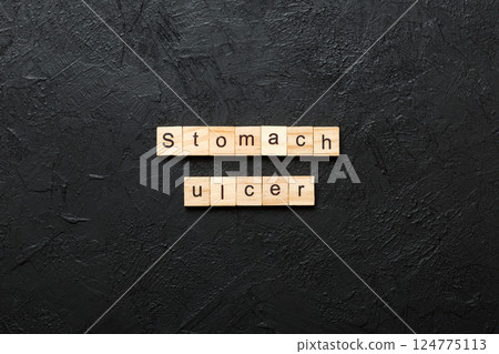stomach ulcer word written on wood block. stomach ulcer text on table, concept 124775113