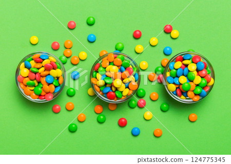 different colored round candy in bowl and jars. Top view of large variety sweets and candies with copy space 124775345