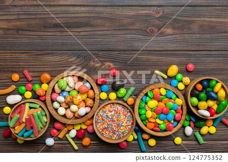 different colored round candy in bowl and jars. Top view of large variety sweets and candies with copy space different colored round candy in bowl and jars. Top view of large variety sweets and candies with copy space 124775352