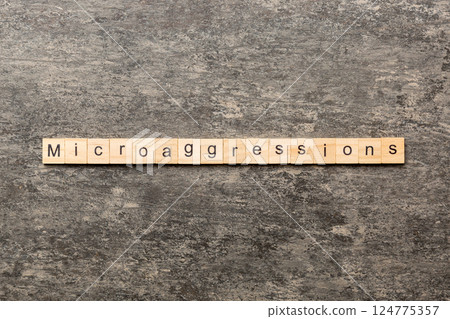 Microaggressions word written on wood block. Microaggressions text on cement table for your desing, concept Microaggressions word written on wood block. Microaggressions text on cement table for your desing, concept 124775357