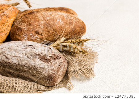 Homemade natural breads. Different kinds of fresh bread as background, perspective view with copy space Homemade natural breads. Different kinds of fresh bread as background, perspective view with copy space 124775385