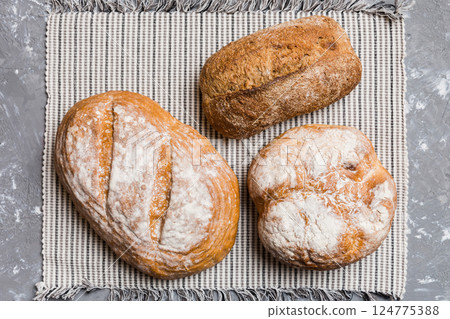 Assortment of freshly baked bread with napkin on rustic table top view. Healthy unleavened bread. French bread 124775388