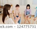 Happy Asian kids in a classroom actively participating in a lesson, capturing the essence of group learning, communication, and engagement in a diverse primary education setting 124775731