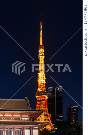 Tokyo Tower glows with golden lights beside Zojo-ji Temple under the night sky 124775962