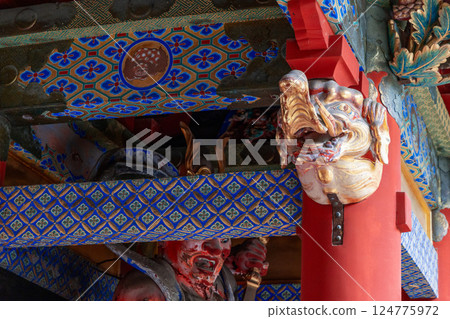 Carved wooden sculpture of a mythical creature on red pillar traditional Japanese temple in Nikko 124775972