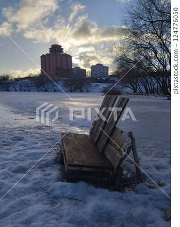 Old Wooden Bench on Frozen Lake at Winter Sunset Old Wooden Bench on Frozen Lake at Winter Sunset 124776050