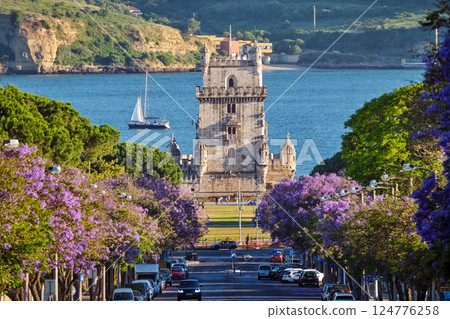Belem Tower in Lisbon Framed by Blooming Jacaranda Trees and Sailboats on the Tagus River, Portugal Belem Tower in Lisbon Framed by Blooming Jacaranda Trees and Sailboats on the Tagus River, Portugal 124776258