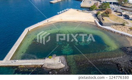 March 23 2025 Coastal Sandy Cove with Clear Turquoise Waters and Stone Walls, Japan March 23 2025 Coastal Sandy Cove with Clear Turquoise Waters and Stone Walls, Japan 124776380