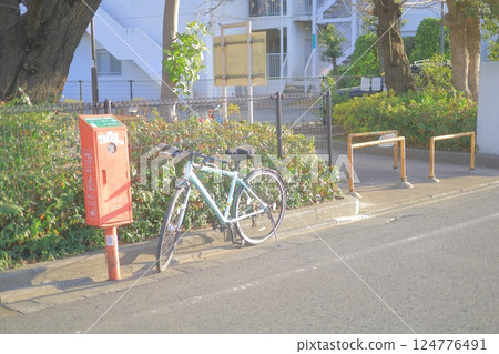 Bicycle and postbox in front of the park Bicycle and postbox in front of the park 124776491