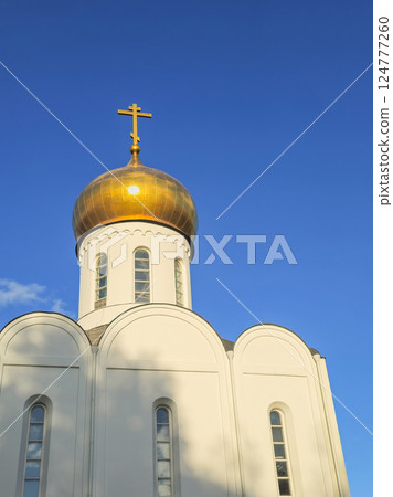 white Orthodox church with sunlit gilded dome white Orthodox church with sunlit gilded dome 124777260