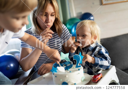 Celebration with young children and a cake at a birthday party at home in the afternoon 124777558