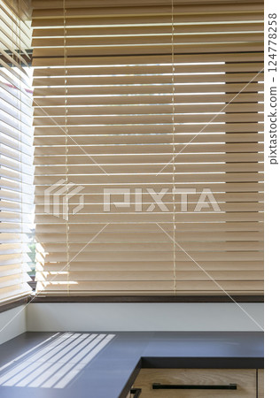 Modern kitchen with wood blinds on windows 124778258