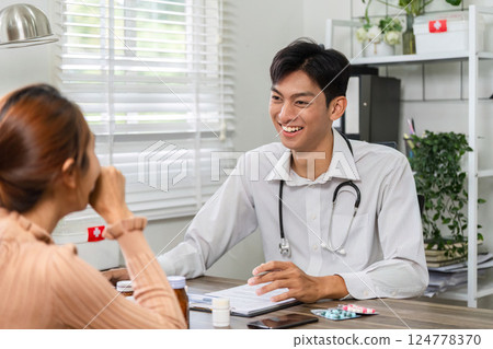 Doctor and Patient Interaction. A healthcare professional communicating with a patient during a consultation. 124778370