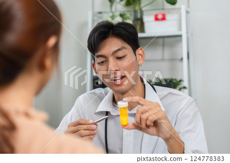 Patient Consultation and Medication Guidance. Doctor engaging with a patient while presenting a prescription bottle. 124778383
