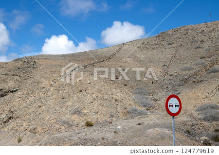 Arid ground on the hills and traffic sign, Gran Canaria, Spain Arid ground on the hills and traffic sign, Gran Canaria, Spain 124779619