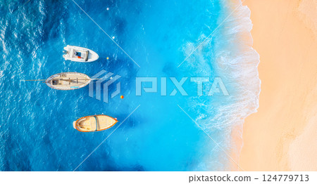 Drone view of a boats. Marine transport. Beach and waves. Vacation and holidays. Aerial landscape. Drone view of a boats. Marine transport. Beach and waves. Vacation and holidays. Aerial landscape. 124779713