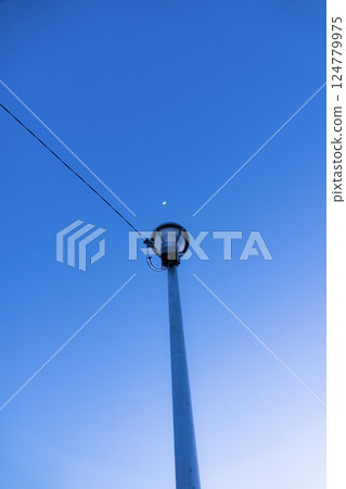 路燈和月亮在藍色的天空中亮起 124779975