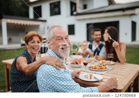 Family sitting at table and eating delicious food during spring family barbecue. Family sitting at table and eating delicious food during spring family barbecue. 124780669
