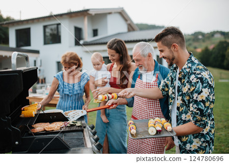 Three generations of family preparing food for a spring weekend barbecue. 124780696