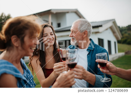 Family toasting with wine during spring family barbecue. Family toasting with wine during spring family barbecue. 124780699