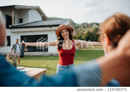 Parents welcoming their daughter at a family barbecue. 124780771