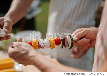 Close up of family preparing food for a spring weekend barbecue. 124780777
