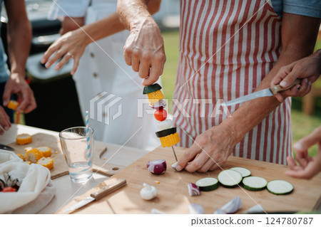 Close up of family preparing food for a spring weekend barbecue. 124780787