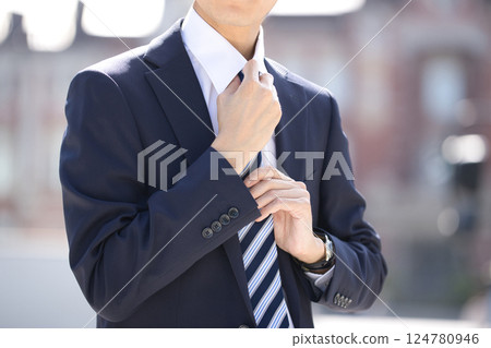 站在商業區的一位西裝革履的年輕人 站在商業區的一位西裝革履的年輕人 124780946