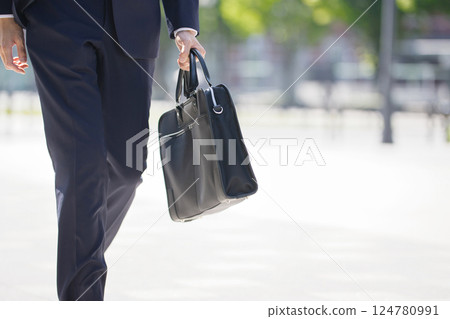 The feet of a young man in a suit walking through a business district The feet of a young man in a suit walking through a business district 124780991