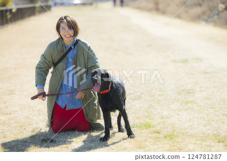 A woman walking a dog A woman walking a dog 124781287