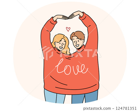 Couple in love wearing same sweater together makes heart shape from hands in sympathy sign Couple in love wearing same sweater together makes heart shape from hands in sympathy sign 124781351
