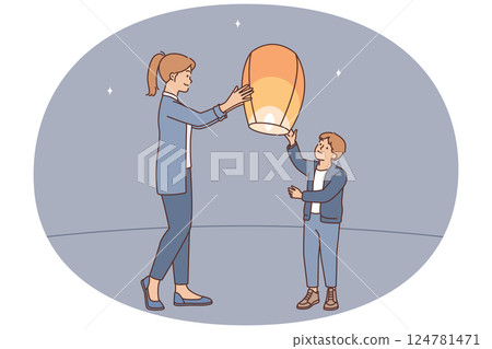 Teenage boy together with older sister launch air fire lantern standing on street under starry sky 124781471