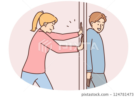Positive man hides behind door preventing girlfriend from passing or arranging prank 124781473