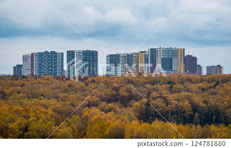 Yellow autumn forest on the background of multi-storey residential buildings. Yellow autumn forest on the background of multi-storey residential buildings. 124781880