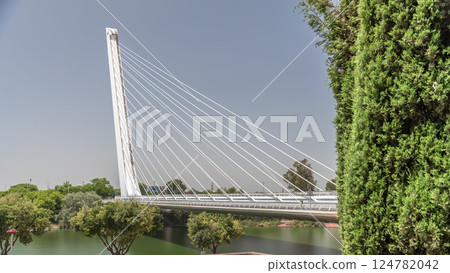 Alamillo Bridge with tall pylon and steel cables crossing over Guadalquivir River timelapse hyperlapse in Seville, Spain Alamillo Bridge with tall pylon and steel cables crossing over Guadalquivir River timelapse hyperlapse in Seville, Spain 124782042