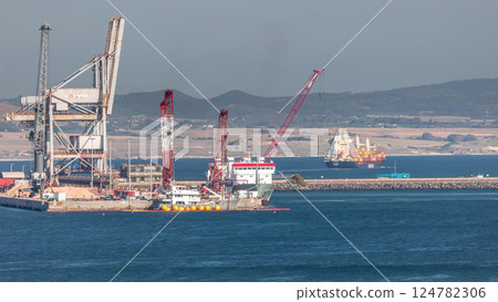 Aerial view of container cargo terminal of commercial port timelapse, business logistics and transport industry in Sines, Portugal. Aerial view of container cargo terminal of commercial port timelapse, business logistics and transport industry in Sines, Portugal. 124782306