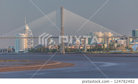 Vasco da Gama Bridge over river Tagus timelapse in Lisbon with park of Nations district modern architecture, Portugal 124782482