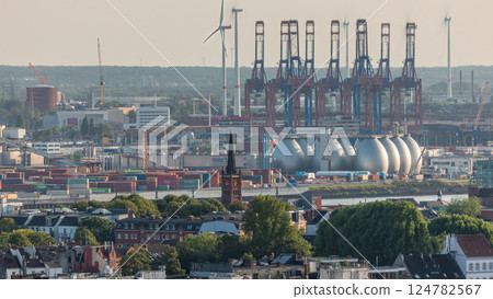 Aerial timelapse of Hamburg cargo port, showcasing container terminals, cranes and cargo ships on the Elbe River. 124782567
