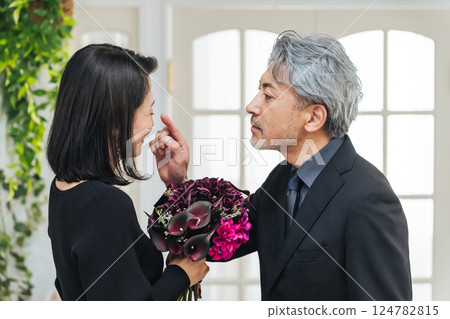 Middle-aged couple handing over a bouquet 124782815