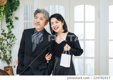 A middle-aged couple walking in front of a shop 124782817
