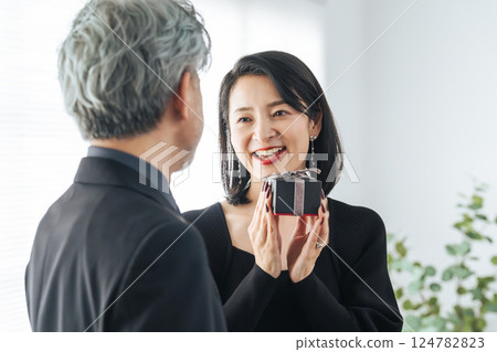 Middle-aged couple giving a present Middle-aged couple giving a present 124782823
