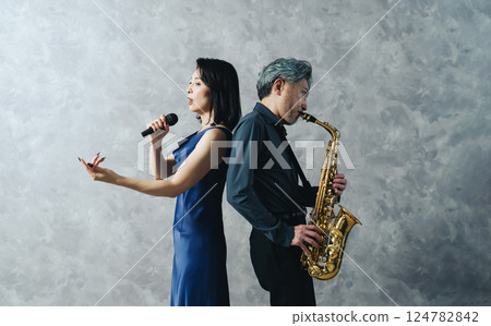 一名男子吹奏薩克斯風,女歌手唱歌 一名男子吹奏薩克斯風,女歌手唱歌 124782842