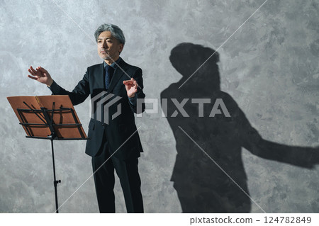 A middle-aged male conductor conducting 124782849