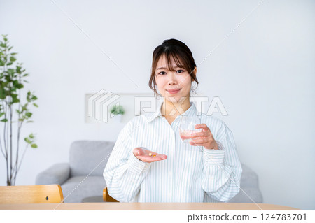 A young woman who takes medicine 124783701