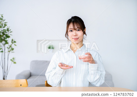 A young woman who takes medicine 124783702