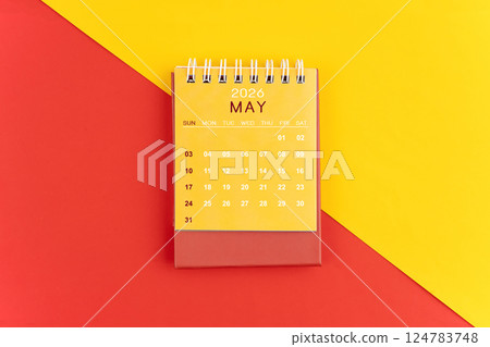 May 2026 desk calendar on red and yellow background. 124783748