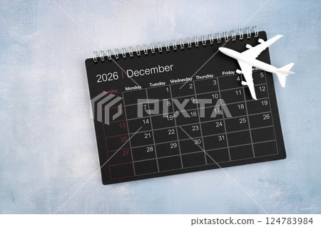 December 2026 black calendar and airplane toy on wooden table. 124783984