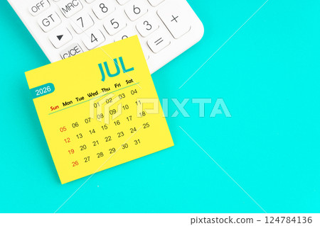 July 2026 calendar page with calculator on blue background. 124784136