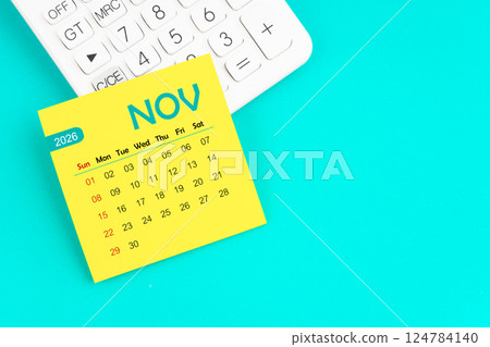 November 2026 calendar page with calculator on blue background. 124784140